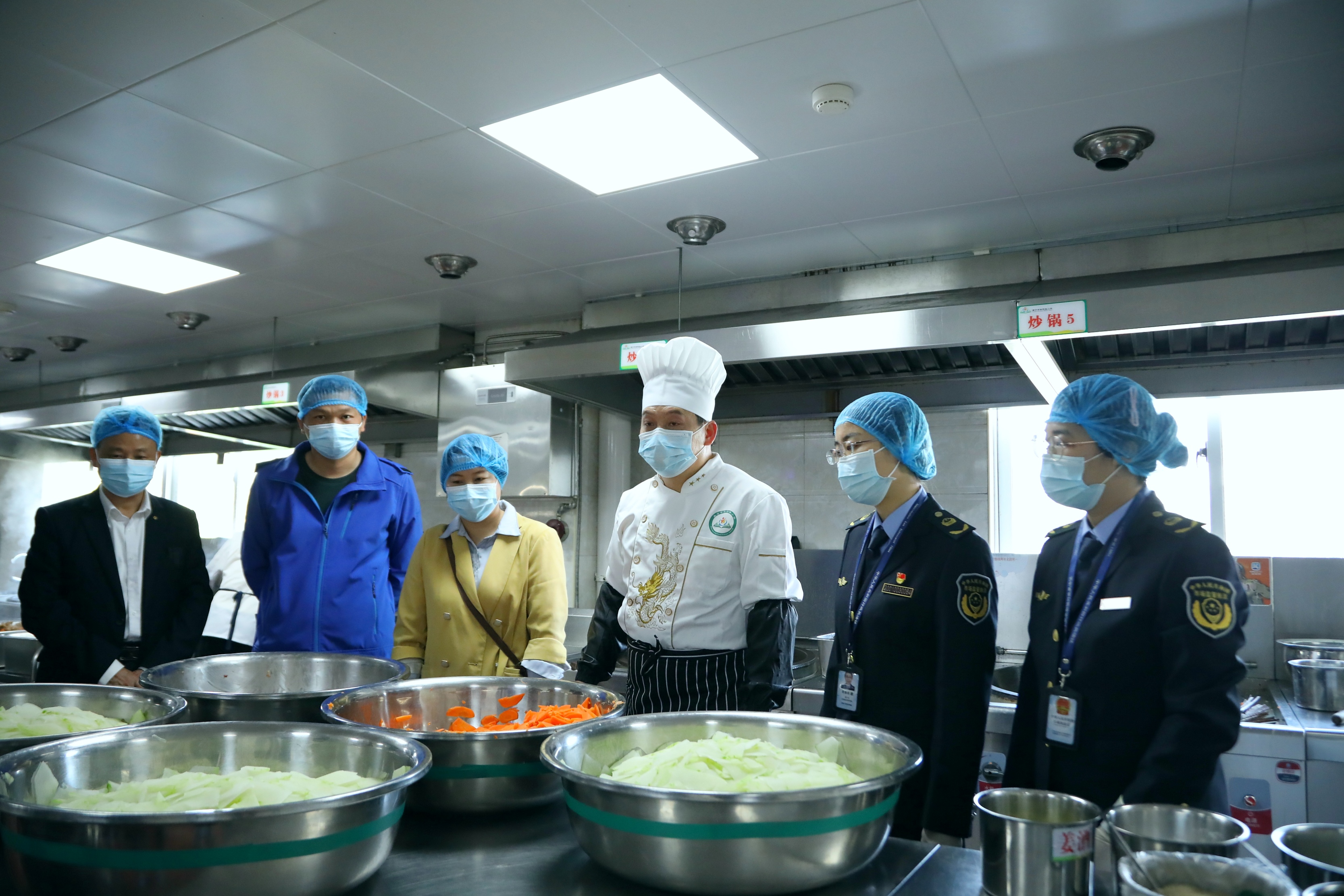 南寧市市場監(jiān)管局高新分局執(zhí)法人員對學(xué)校食堂后廚進(jìn)行檢查。（何正君 攝）.jpg