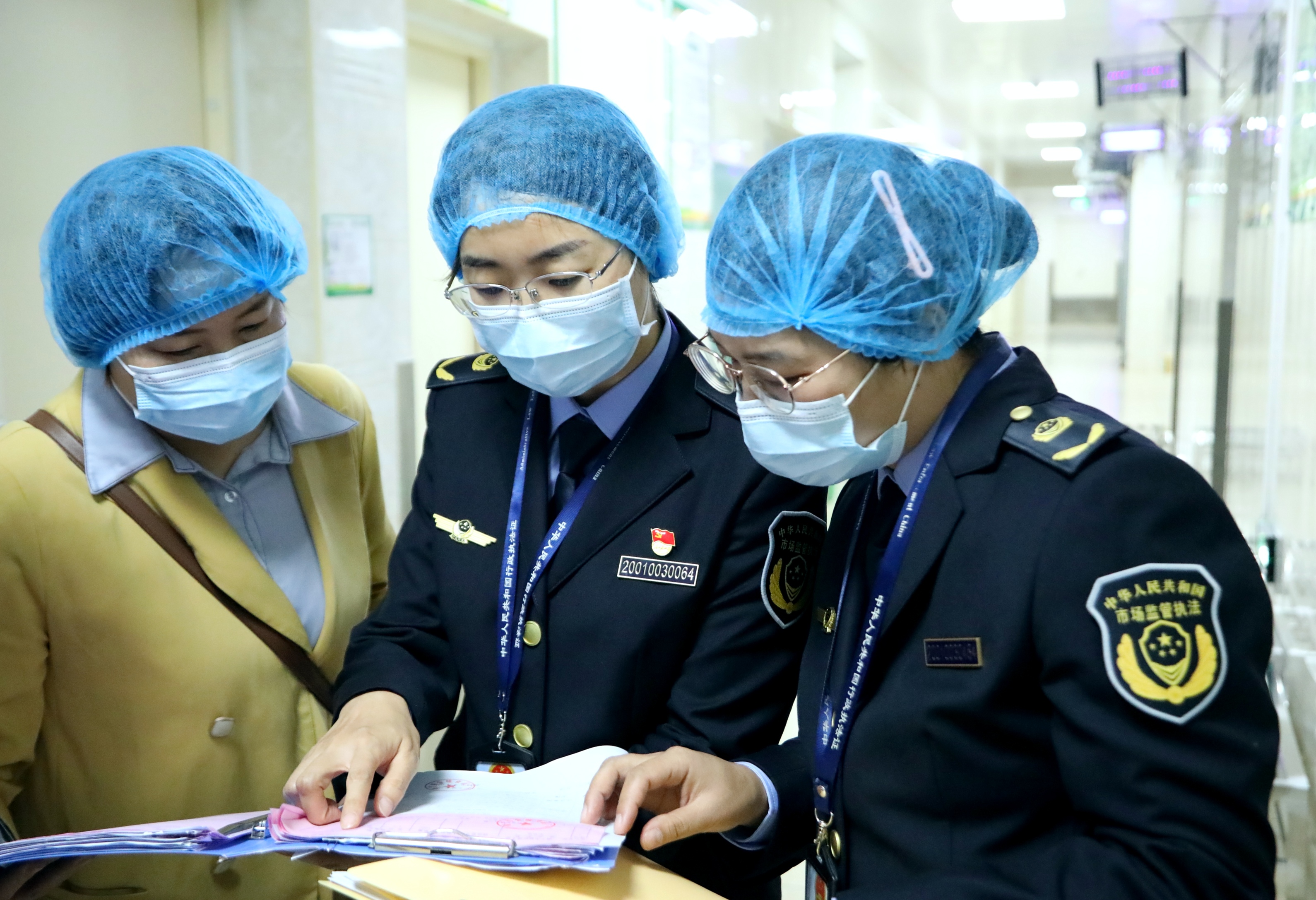 南寧市市場監(jiān)管局高新分局執(zhí)法人員對食堂的采購臺賬及索票索證檔案進(jìn)行檢查。（何正君  攝）.jpg